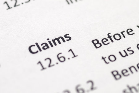 A macro shot of a legal or insurance document with the word "Claims" and section number "12.6.1" in sharp focus, symbolizing the process of seeking compensation.の写真素材