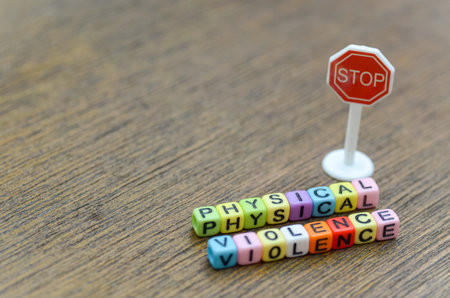The words "PHYSICAL VIOLENCE" next to a miniature red stop sign deliver an unambiguous plea to halt all forms of aggression and create a safe environment.の写真素材