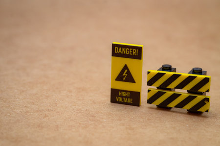 A "DANGER! HIGH VOLTAGE" warning sign and safety barrier clearly mark a restricted area, emphasizing workplace electrical safety and cautionの写真素材