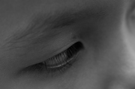 A beautifully captured monochrome image of an eye, where the sharp focus on the lashes and contour evokes a sense of deep thought, scrutiny, and awareness.の写真素材