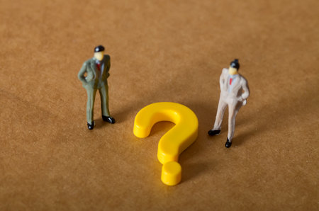 Two business figures face a large question mark, symbolizing a critical business decision, strategy dilemma, and the need for professional consultationの写真素材