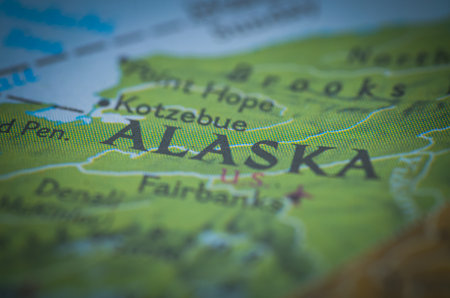 A map with selective focus sharply highlights the word "ALASKA," emphasizing the vast geography of the United States' northernmost state.の写真素材