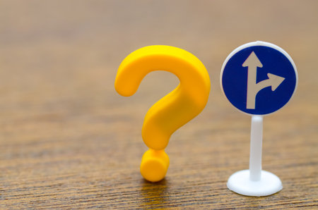 A question mark beside a road sign symbolizes the dilemma of making a choice when the path forward is unclear.の写真素材
