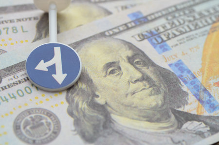The Direction of Money: This conceptual image, with a diverging arrow on a US dollar, represents financial choices, economic divergence, and strategic fund splitting.の写真素材