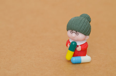 Elderly Woman Miniature Clutches Large Pill: A Conceptual Look at Medication and Age.の写真素材