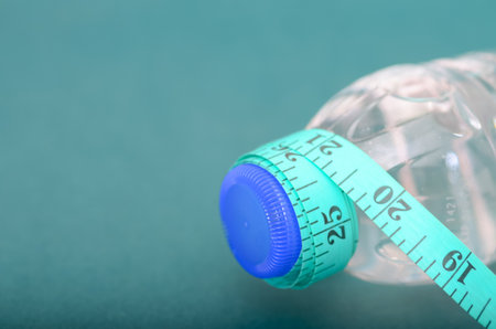 Diet and Fitness Composition Featuring Water Bottle and Teal Tape Measureの写真素材