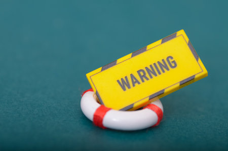 Danger and Safety Symbolism: Warning Text on Sign in a Floating Life Saving Ringの写真素材