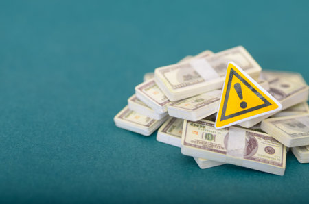 Risk Assessment and Caution: Yellow Triangle Signage Signaling Danger in Business and Finance against green Backdropの写真素材