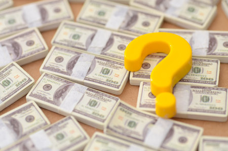 Financial Uncertainty Concept With Yellow Question Mark And Miniature Money Stacksの写真素材