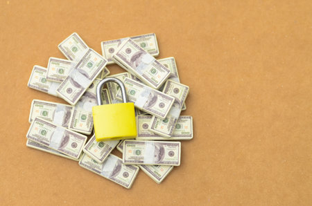 Financial Security Concept: Locked Pile of Cash on Tan Backgroundの写真素材
