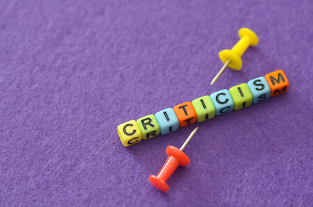 Criticism Concept: Text Made of Wooden Cubes on Tableの写真素材