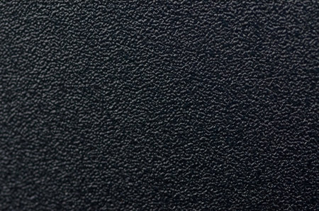 Dark Black Textured Plastic Surface with Industrial Stippled Grain Patternの写真素材