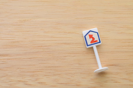 Red Zigzag Arrow Sign on Wooden Surface Representing Housing Trends