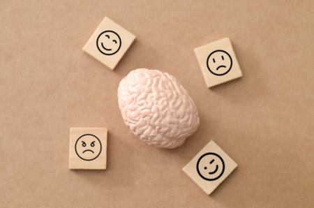 Psychology and Cognitive Science Concept: Brain with Happy, Sad, and Angry Emoticons