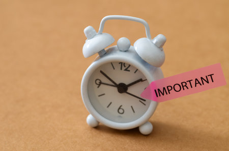 Time Management Urgency: Minimalist Clock on Tan Background with Important Pointer