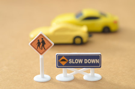 School Safety Concept Featuring Miniature Pedestrian, Bus Stop, and Speed Bump Traffic Signsの写真素材