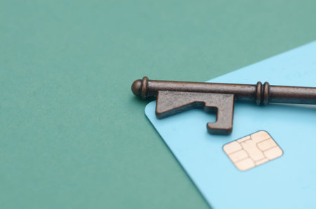 Brass Key Placed on Blue Smart Card with Gold Chip Symbolizing Digital Securityの写真素材