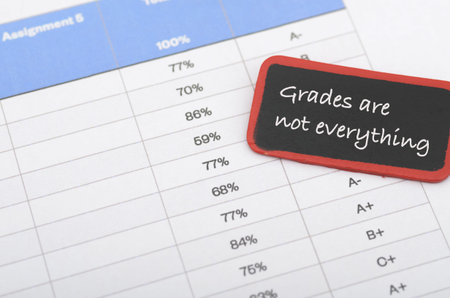 Education concept featuring grades are not everything quote and grading sheet