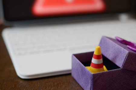 Cyber threat alert and system under construction concept showing safety cone on keyboard