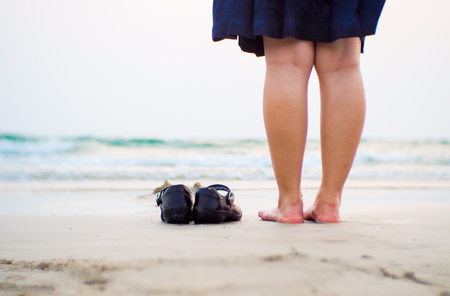 Beach travel - young girl  , woman walking on sand beach leaving footprints in the sand. Closeup detail of female feet and golden sand on beach in Hawaii. - Imageの写真素材