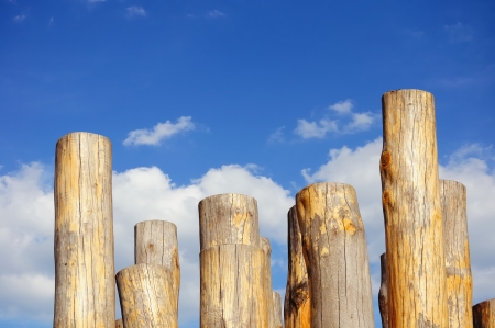Wooden columns against cloudy blue skyの写真素材