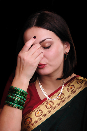 Young caucasian dark-haired pretty woman in traditional indian sari. (Studio low key shot)の写真素材
