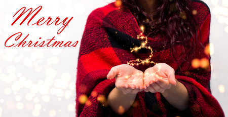 Girl's hands holding Christmas tree made of sparkles and magic with text Merry Christmasの写真素材