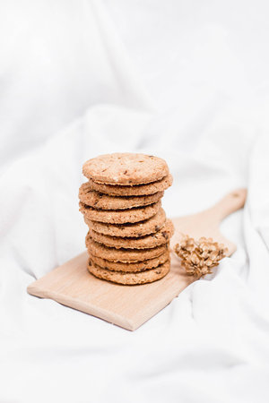 Close up of a sweet homemade cookies on a wooden board with dry herbの写真素材