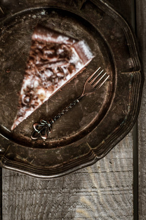 Chocolate birthday cake with flowers, cup of coffee and present box on a wooden tableの写真素材