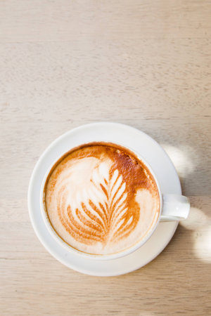 Decorated coffee cappuccino on a wooden tableの写真素材