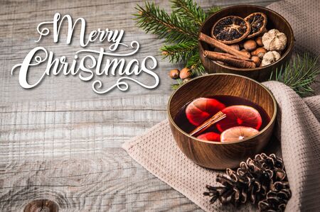 Fruit tea with cinnamon and lemon and decoration on a wooden background with text Merry Christmasの写真素材