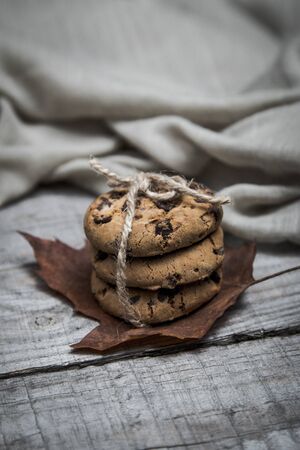 Close up of a delicious homemade chocolate cookies with a rope on a wooden table