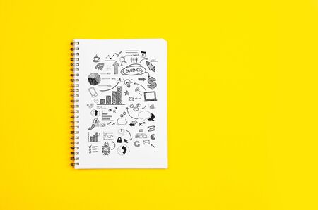 White paper page with doodles and business strategies on a yellow backgroundの写真素材