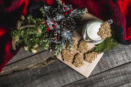 Fresh milk and Christmas cookies with Christmas decorations on a wooden tableの写真素材