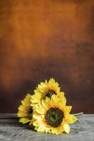 Beautiful sunflowers laying on a wooden table with vintage backgroundの写真素材