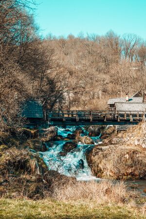 Beautiful waterfalls in the middle of the nature with wooden housesの写真素材