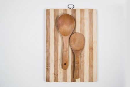 Wooden cutting board with wooden spoons on a table
