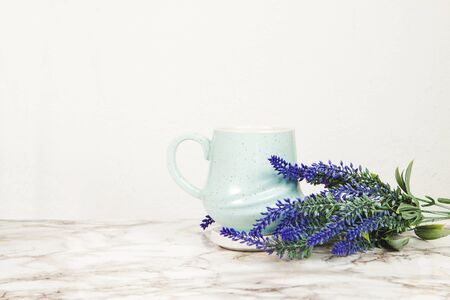 Lavender flowers and pastel blue mug on a marble tableの写真素材