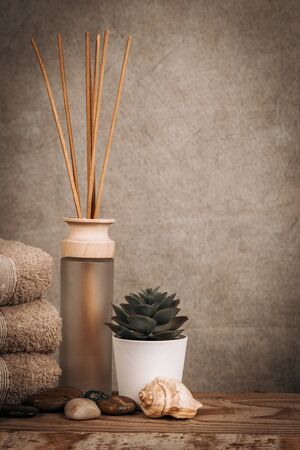 Spa essentials, aroma sticks, stones, towels, sea shell on a wooden rustic backgroundの写真素材
