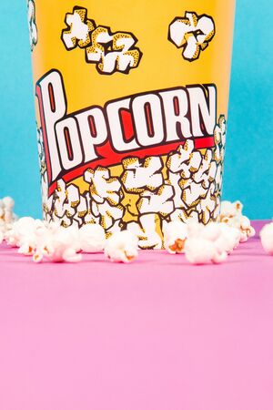 Yellow box of fresh popcorns on a pink and blue backgroundの写真素材