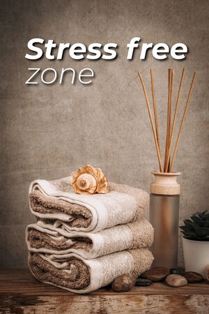Spa essentials, candle, stones, towel and flowers on a dark rustic backgroundの写真素材