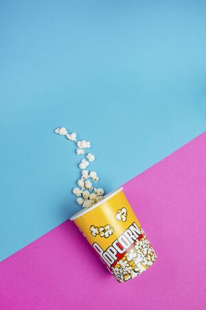 Yellow popcorn box on a blue and purple backgroundの写真素材