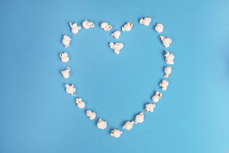 Romantic heart made out of popcorn on a blue backgroundの写真素材