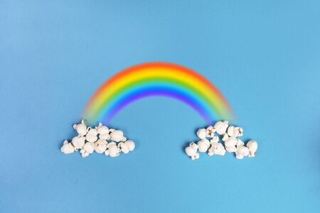 Popcorn clouds on a blue background with the colorful rainbowの写真素材