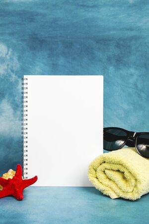 White blank page with the towel, sunglasses and starfish on a blue backgroundの写真素材