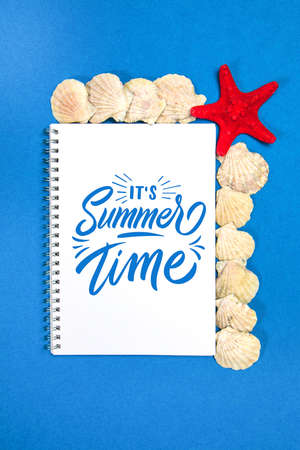 Starfish and seashells on a blue background with white page and text Summer Timeの写真素材