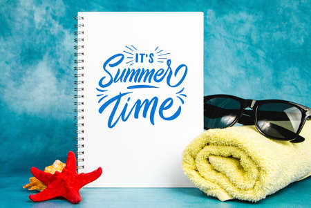 White blank page with the towel, sunglasses and starfish on a blue backgroundの写真素材