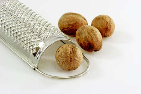 Close up of four nutmegs with a graterの写真素材