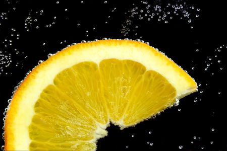 Splashing slice lemon in water on black backgroundの写真素材