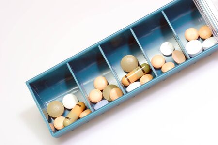 Pill boxes indicating days of the day with pills  on bright Background